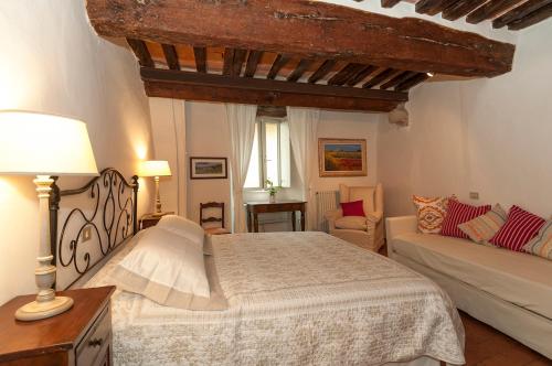 1 dormitorio con 1 cama grande y 1 sofá en B&B Arena di Lucca, en Lucca