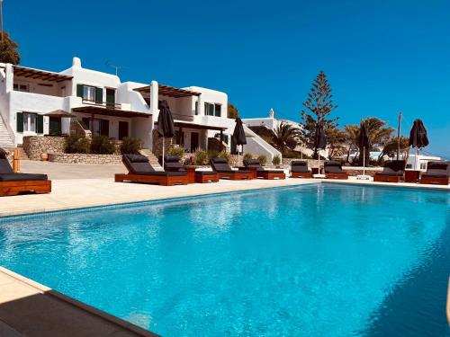 a swimming pool in front of a villa at Seethrough Mykonos Suites in Platis Yialos Mykonos