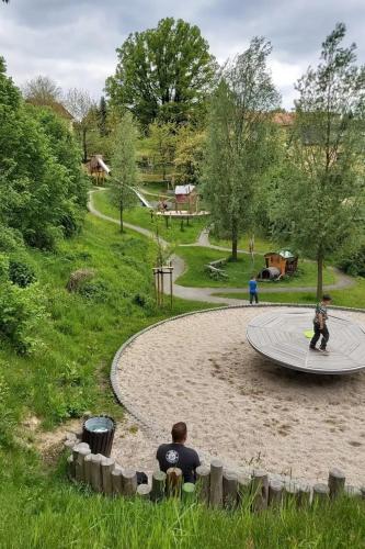 two people sitting in the sand in a park at Cosis Ferienwohnung in Hohnstein