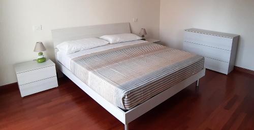 a bedroom with a large bed and a night stand at ArmacHouse - Appartamenti sul mare in Reggio Calabria