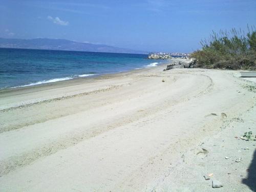 a sandy beach with the ocean in the background at ArmacHouse - Appartamenti sul mare in Reggio Calabria
