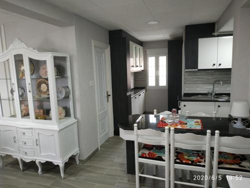 Apartamento Laxe con vistas al mar في لاتشي: مطبخ مع خزانة بيضاء وطاولة طعام