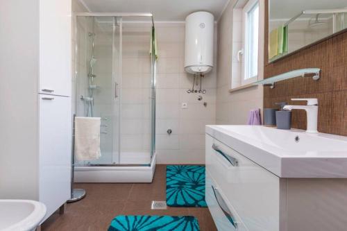 een badkamer met een douche, een wastafel en een douche bij Predivan novouređeni apartman u blizini mora in Banjole