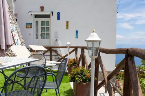 un patio con mesas y sillas y una valla en Holidays Perla d'Amalfi, en Amalfi