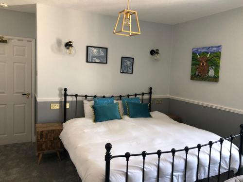 a bedroom with a large bed with blue pillows at The Black Bull Inn in Middleham