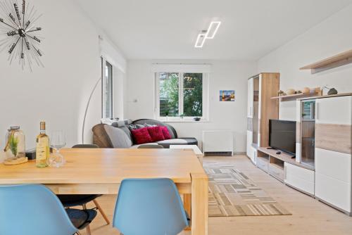 a living room with a wooden table and chairs at TTP 13 Gartenoase beim Wassertürmchen Immenstaad in Immenstaad am Bodensee