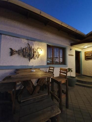 una mesa de madera y sillas en un patio en Salty Jackal Backpackers & Surf Camp en Swakopmund