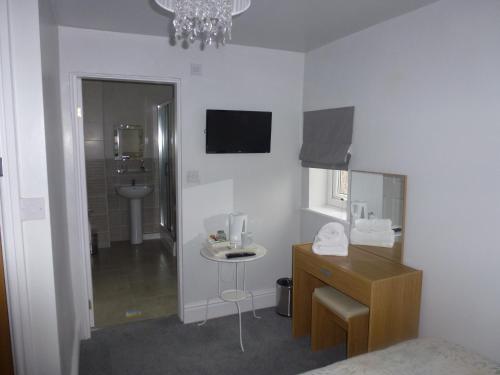 Habitación con baño con lavabo y espejo. en Orrell Park Hotel, en Liverpool