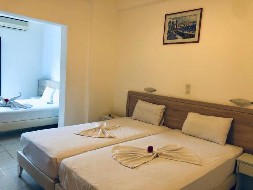 a hotel room with two beds with bows on them at Flisvos Rooms in Frangokastello