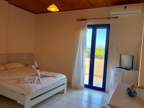 a bedroom with a bed and a sliding glass door at Flisvos Rooms in Frangokastello