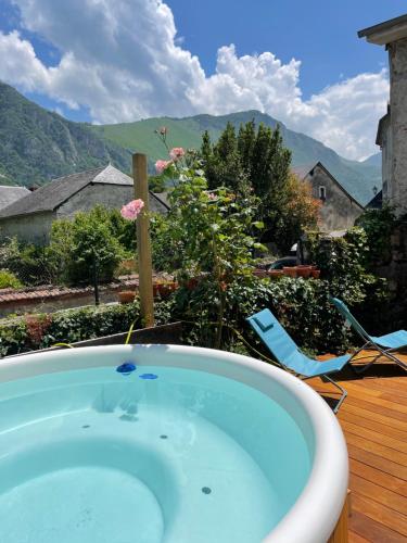 a jacuzzi tub on a deck with a view at Le Monrepos avec jacuzzi nordique in Bielle