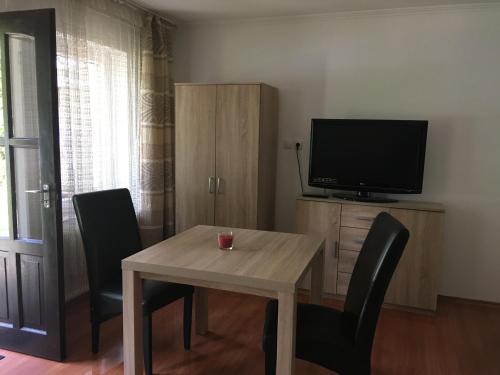 a dining room with a table and a television at Bakonyi Kemencésház in Bakonybél