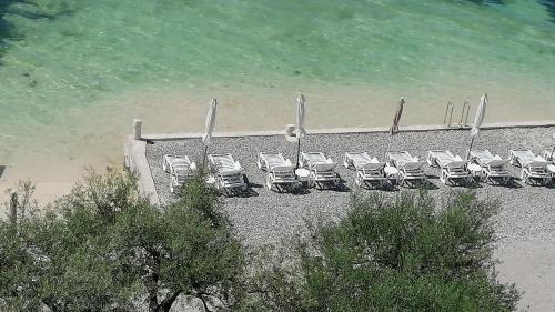 a group of chairs on a beach next to the water at Olea in Tivat