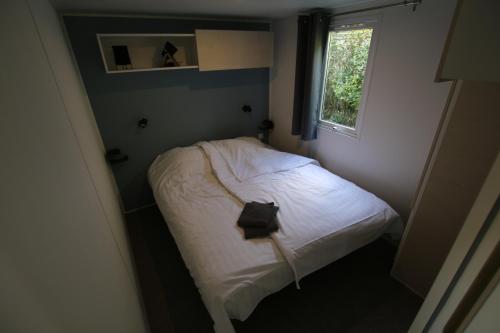Cama pequeña en habitación pequeña con ventana en Loggia Camping Belle-Vue 2000, en Berdorf
