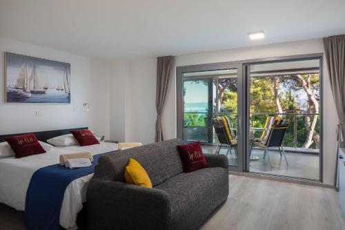 a bedroom with a bed and a couch and a balcony at VILLA AQUA - Adults Only in Bol