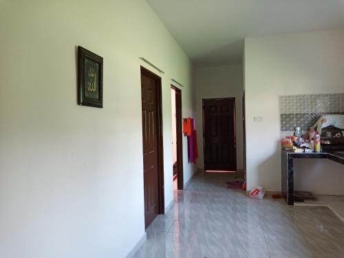a room with a hallway with two doors and a counter at Nurul Saadah Lunas in Lunas