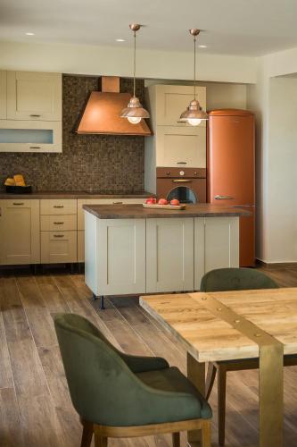 a kitchen with a wooden table and a kitchen with a refrigerator at Echos Villa in Argostoli