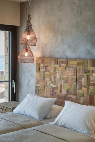 a bedroom with two beds and two hanging lights at Echos Villa in Argostoli