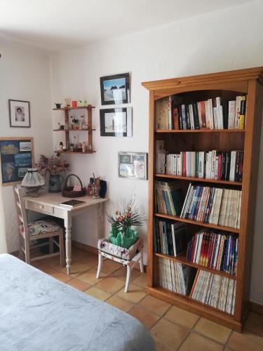 een slaapkamer met een bureau en een boekenplank gevuld met boeken bij Villa Kyrae in Oraison