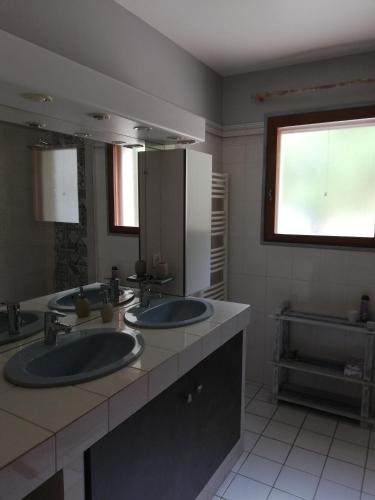 une salle de bain avec deux lavabos et un grand miroir dans l'établissement Villa Kyrae, à Oraison