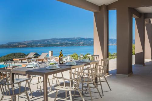 a dining table with chairs and a view of the ocean at Echos Villa in Argostoli
