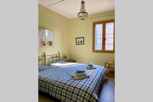 a bedroom with a bed with a blue and white blanket at Barchessa Ca’ Leon sul naviglio del Brenta in Mira