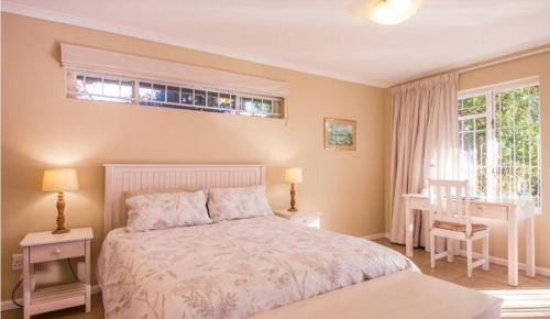 a bedroom with a bed and a desk and a window at Squirrel's End in Cape Town