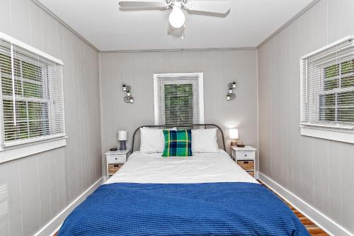 a bedroom with a bed and two windows at Camelback cottage - on ONE ACRE & near local attractions in Tannersville