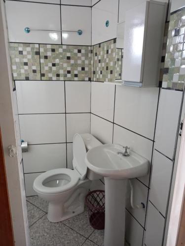 a bathroom with a toilet and a sink at Apartamento avenida 04 com ar condicionado in São Thomé das Letras
