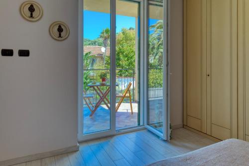 Habitación con puertas correderas de cristal que dan a un patio. en Appartamento Alice - Cervo, en Cervo