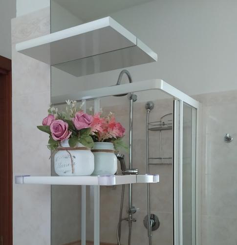 a shelf with flowers on it in a bathroom at La Casa al Colle in Treglio
