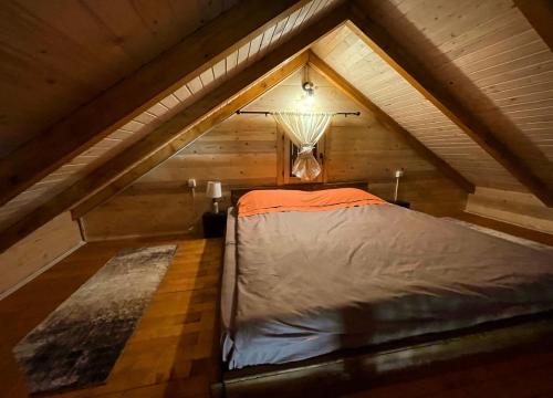 a bed in the attic of a room at Cabin House Dubovik in Cetinje
