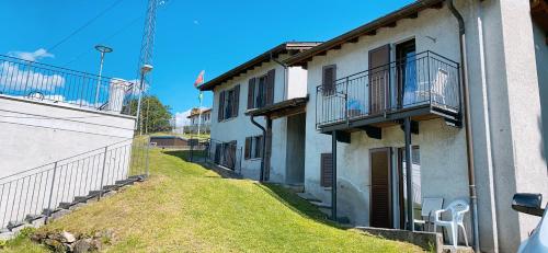 an alley with a building with a balcony and a yard at Casa Locarnesa in Gambarogno