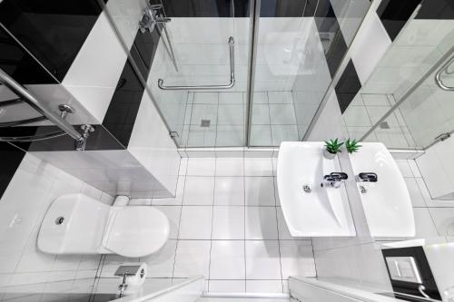 リヴィウにあるLEOGRAND Apartments on Udatnogo 4-2の白いバスルーム(トイレ、シンク付)