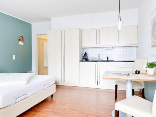 a room with a bed and a desk and a kitchen at Ahrtal Apartments in Bad Neuenahr-Ahrweiler