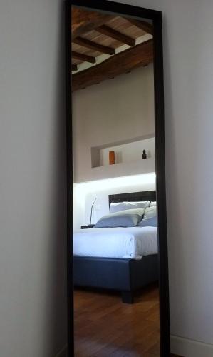 um espelho reflexo de um quarto com uma cama nele em Contemporary Rooms em San Gimignano