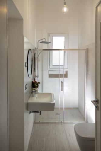 a white bathroom with a sink and a shower at east coast house in Poggiardo