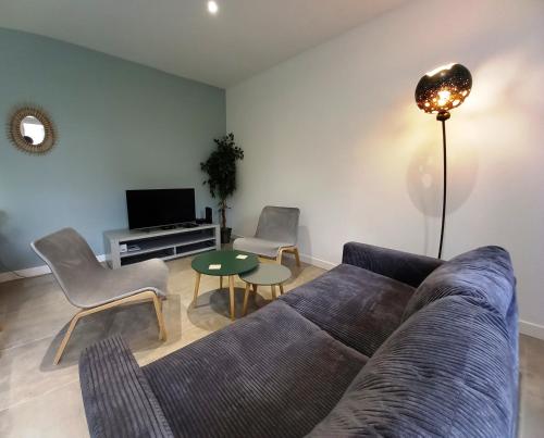 ein Wohnzimmer mit einem Sofa, Stühlen und einem Tisch in der Unterkunft HISTOIRE DE LOIRE - La Maison in Saumur
