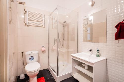 een badkamer met een douche, een toilet en een wastafel bij Laykonik in Krakau