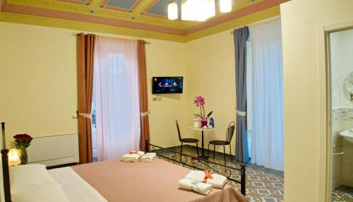 pokój hotelowy z łóżkiem i stołem z krzesłami w obiekcie Domus Aurea w mieście Montalbano Elicona