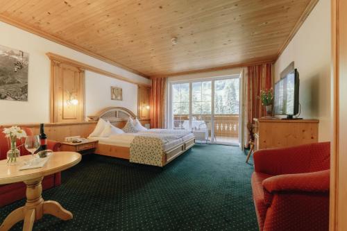 Habitación de hotel con cama y TV en Hotel Hirschen en Silbertal