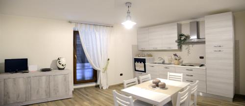 Collepardo的住宿－La Piega，一间带白色桌椅的厨房和一间用餐室