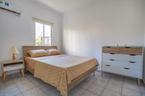 a bedroom with a bed and a dresser and a window at Downtown Larnaca in Larnaca