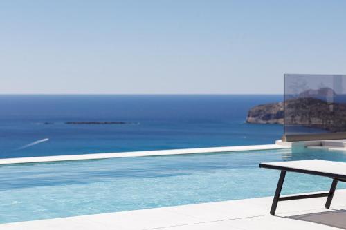 a swimming pool with a table next to the ocean at Falasarna village in Falasarna