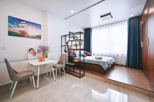a bedroom with a bed and a desk and a table at Qhome in Ho Chi Minh City