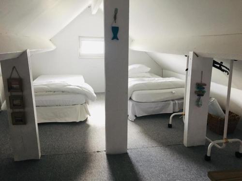 - une chambre blanche avec 2 lits et un miroir dans l'établissement La Longère à la Mer 6 pers 3 chambres grand jardin clôt a Fort-Mahon-Plage, à Fort-Mahon-Plage