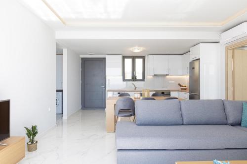 a living room with a blue couch and a kitchen at Falasarna village in Falasarna