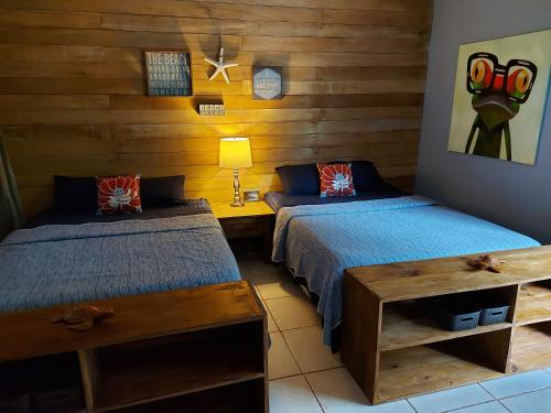 Casa Oceana Bed & Breakfast في بوكاس تاون: سريرين في غرفة بجدران خشبية