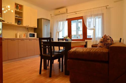a kitchen and living room with a table and a couch at Old Town Residence in Constanţa