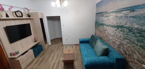 ein Wohnzimmer mit einem blauen Sofa und einem TV in der Unterkunft Old Town Residence in Constanţa